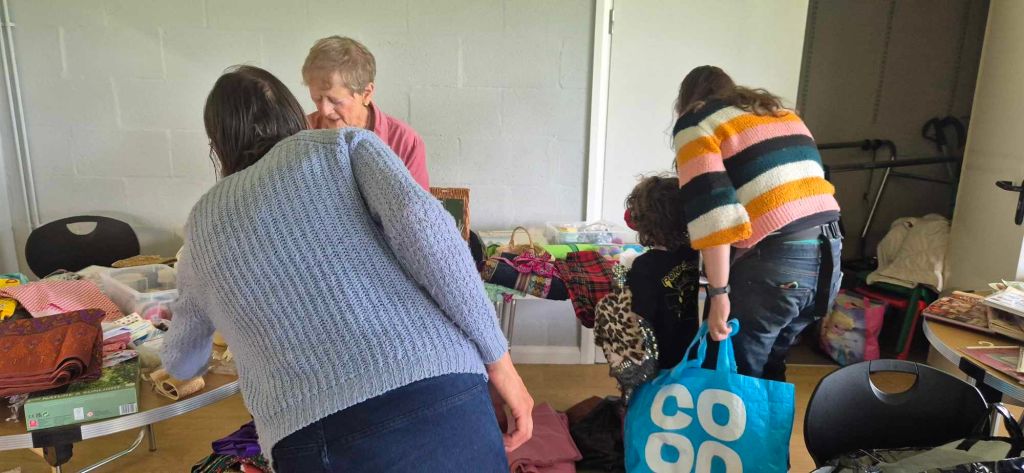 People in a hall looking at tables with craft items placed on them.