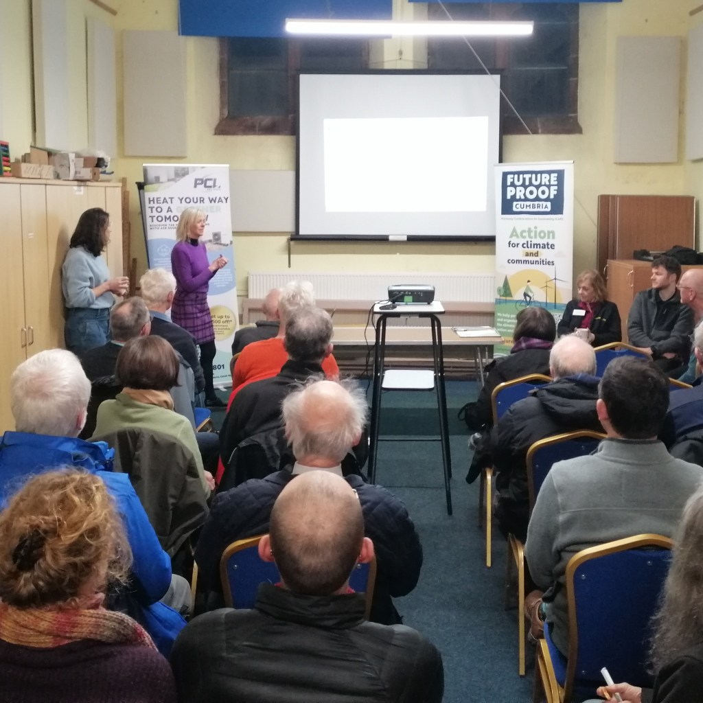 Seated audience watching presentation on heat pumps